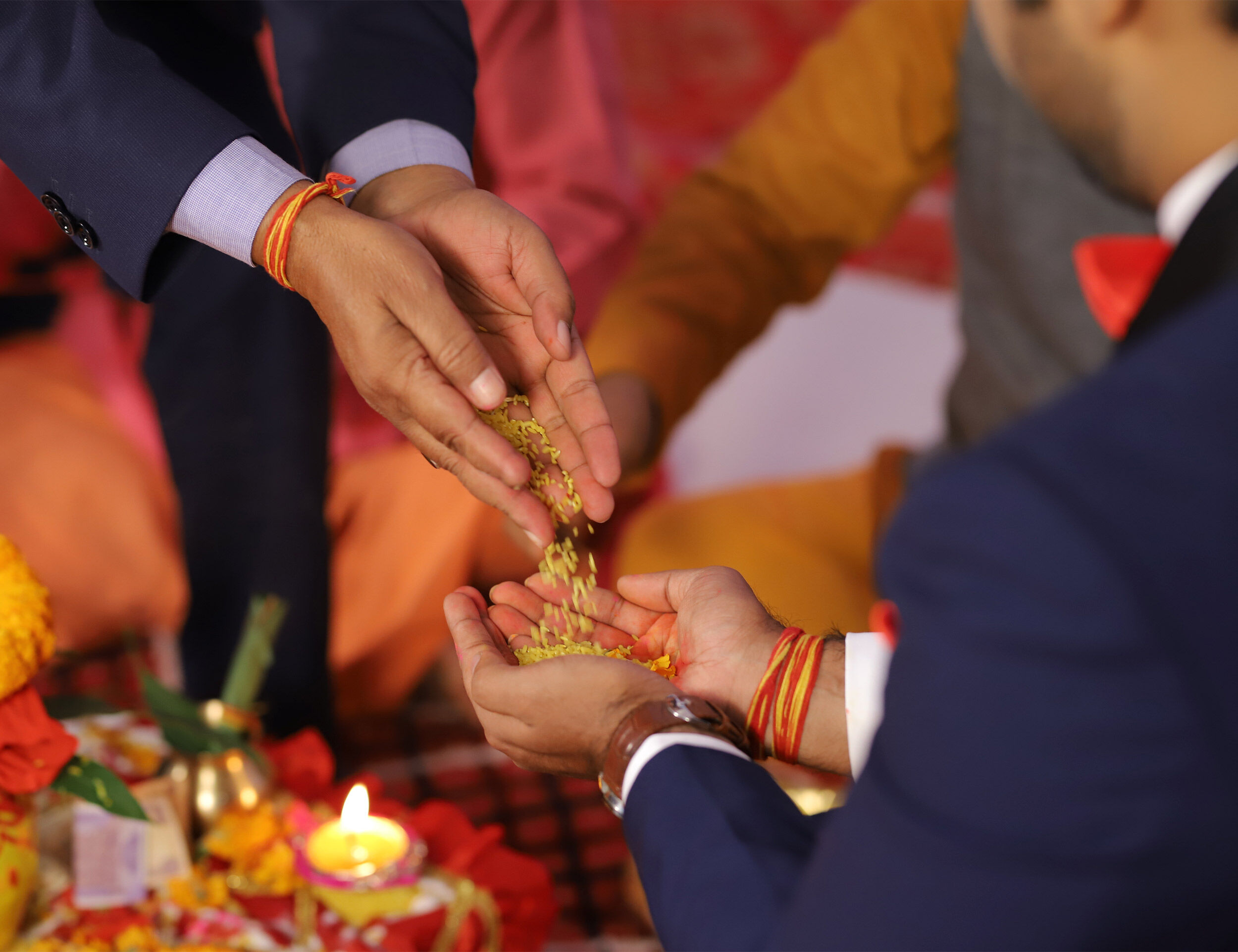 Close-up of a traditional Indian wedding ritual with hands exchanging sacred grains during a puja ceremony